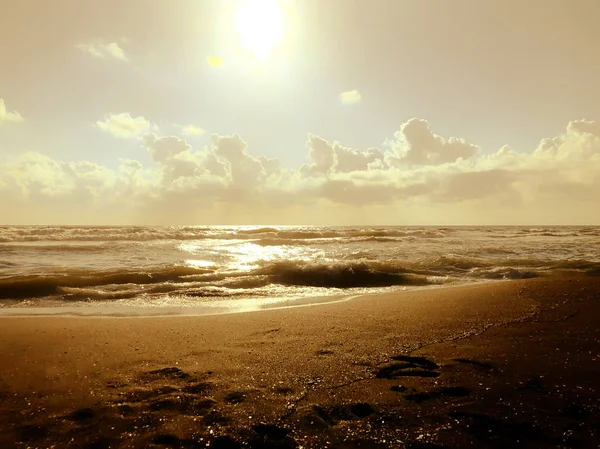 Vista sul mare e sul cielo durante il tramonto. Onde scintillanti su una spiaggia di sabbia. Estate giornata di sole, sfondo acqua — Foto Stock