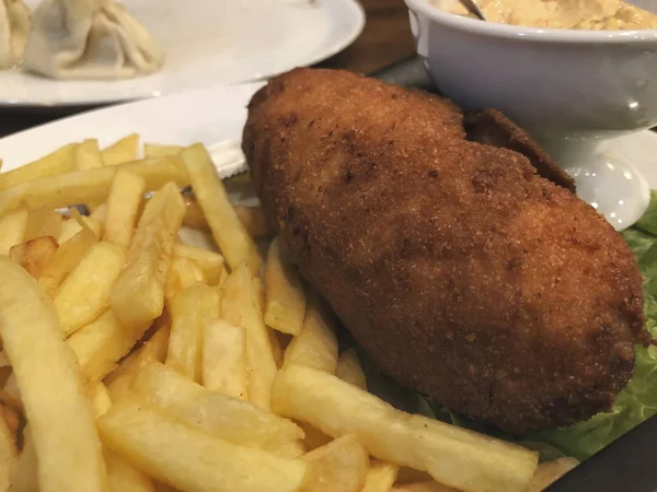 Tradycyjny kotlet w Kijowie z ziemniakami na talerzu, Chicken Kiev. Smaczne jedzenie, kotlety z frytkami — Zdjęcie stockowe