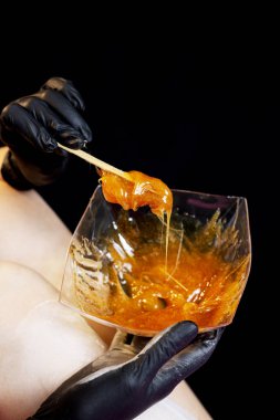 Bacaklar siyah arka plan üzerine liquate şeker ile sugaring epilasyon.