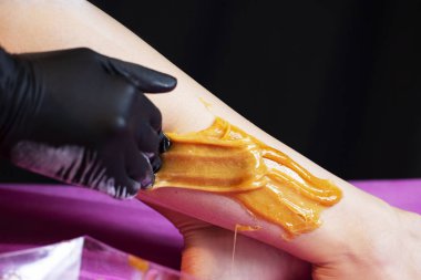 Bacaklar siyah arka plan üzerine liquate şeker ile sugaring epilasyon.