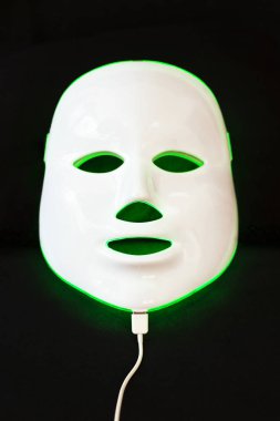 Siyah arka plan üzerine yüz cilt tedavisi için maske gençleştirici ışık.