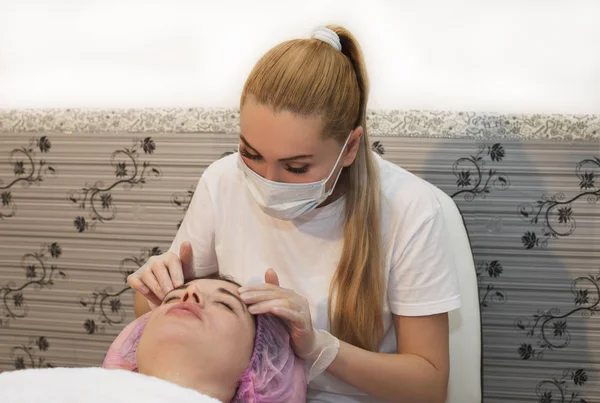 Young woman receiving facial epilation close up. Cosmetologist removes hair on face. Beauty salon, mustache depilation — Stock Photo, Image