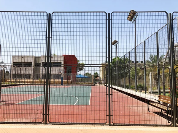 На відкритому повітрі міні футбольний та баскетбольний майданчик з кульковими воротами та кошиком в оточенні високого захисного паркану . — стокове фото