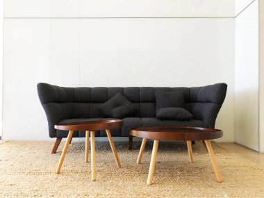 Oturma odası, siyah kanepe, yuvarlak masalar..