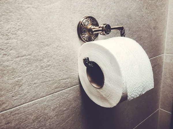 Ρολό λευκό χαρτί τουαλέτας είναι αναρτημένα στην τουαλέτα στον τοίχο. Γκρο πλαν. — Φωτογραφία Αρχείου