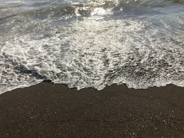Вид на море під час заходу сонця. Блискучі хвилі на піщаному пляжі. Літній сонячний день, водяний фон — стокове фото