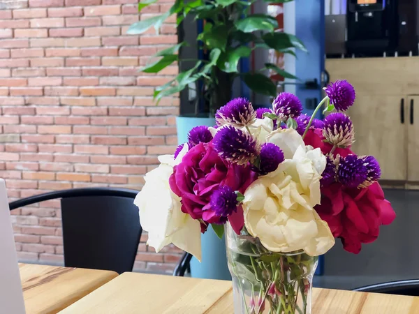 Kır çiçekleri ve kurumuş çiçekler bir bardaktaki suyun içinde bir yol kafeteryasındaki masada. Yakın çekim. — Stok fotoğraf