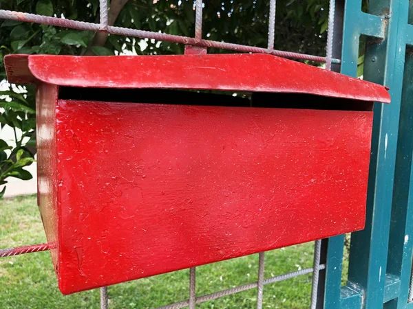 Червона металева поштова скринька на металевому паркані. На відкритому повітрі — стокове фото