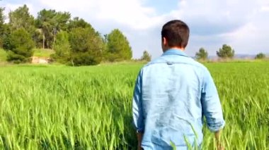 Genç bir adam ormanda yürüyor.