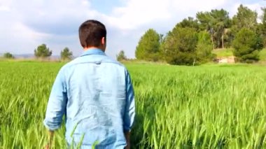 Genç bir adam ormanda yürüyor.