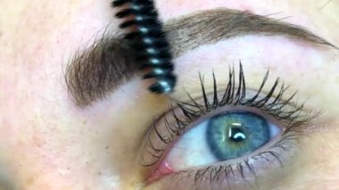 Güzellik uzmanı kadın kaşlarına kalıcı makyaj uygular.