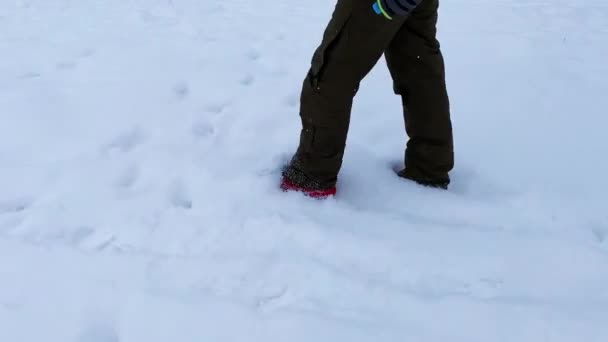 Mladý muž kráčí po sněhu — Stock video