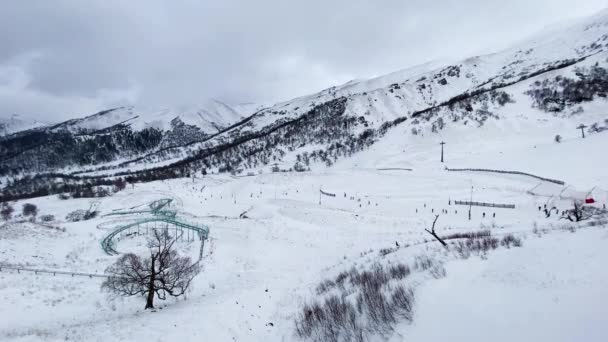 遠くからのバクリアーニの眺め 山を下るスキーヤーは — ストック動画