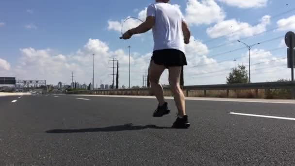 Sportlicher Mann Springt Fantasievoll Mit Einem Springseil — Stockvideo