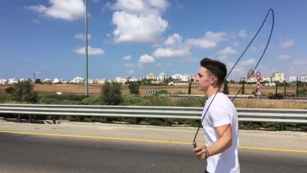 Sportlicher Mann Springt Fantasievoll Mit Einem Springseil — Stockvideo