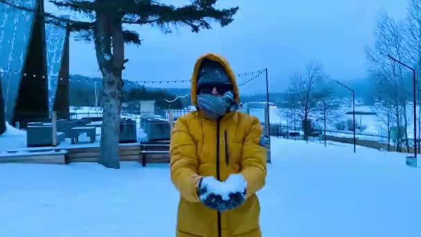 Jongeman gooit sneeuw naar de top — Stockvideo