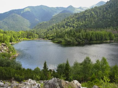 Sable Gölü, Khamar-Daban dalı. Büyük taşlar, saf su, dağlar ve zemin üzerine mavi gökyüzü.