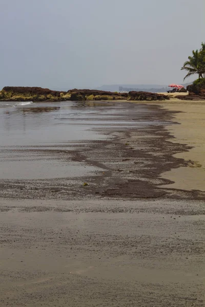 Bitar av oljeprodukter spolas upp på stranden — Stockfoto