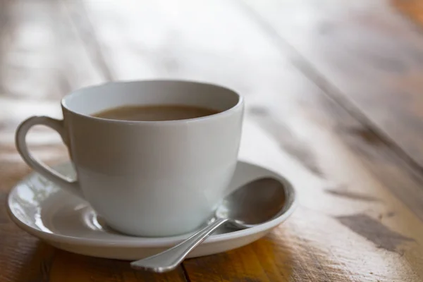 White cup of traditional indian tea masala with sauser and spon