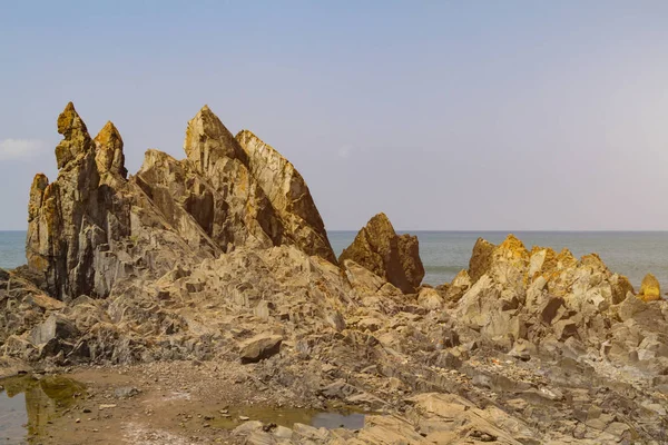 Hindistan'da deniz kıyısında büyük kayalar, Goa