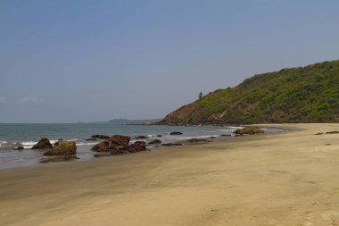 Mavi deniz ve okyanusta sis ile kayalık kıyı. Yeşil dağ ile doğal manzara.