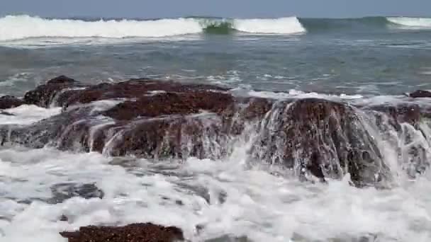 Fuertes olas rompen contra grandes rocas en la orilla . — Vídeo de stock