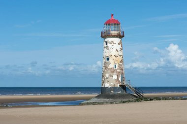 Deniz feneri bir parlak yaz gününde kumlu kıyı şeridi