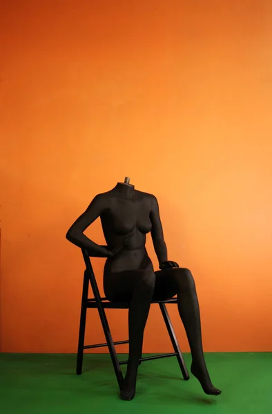 black female mannequin  sitting on chair