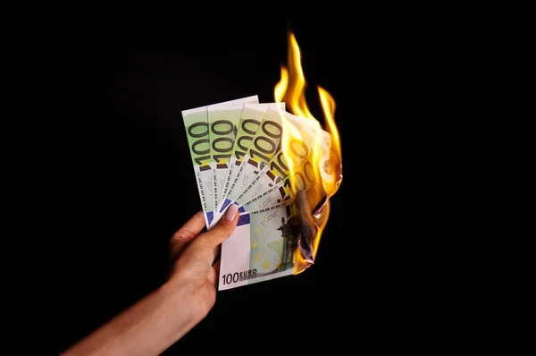 woman  hand with euro banknotes burning