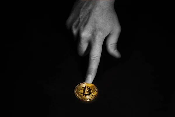 Siyah arkaplanda bitcoin gösteren el