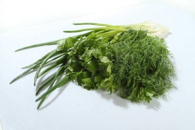 Yeşil sebzeler, soğan, maydanoz, kereviz bir ahşap tahta üzerinde.