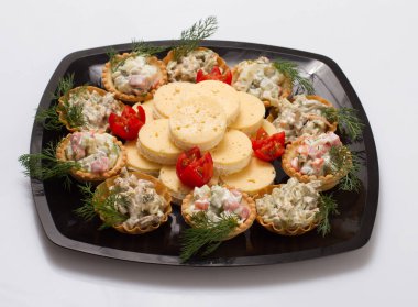 Güzel plaka salata ve yuva siyah bir plaka üzerinde beyaz peynir ile.