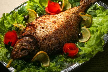 Kızarmış balık çipura marul yaprakları ve sebze.