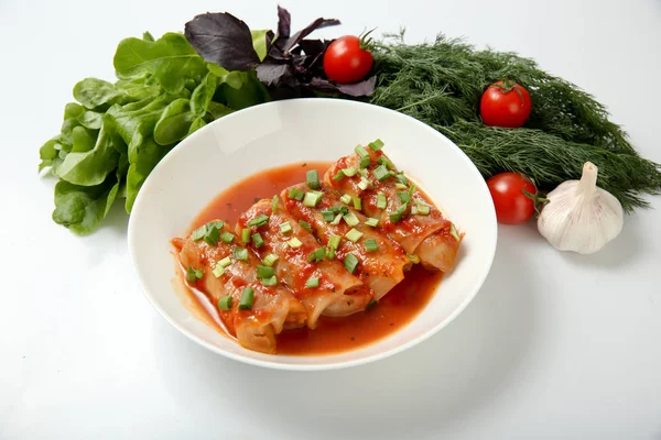 Et ve pilav, domates soslu lahana dolması rulo bir plaka üzerinde.