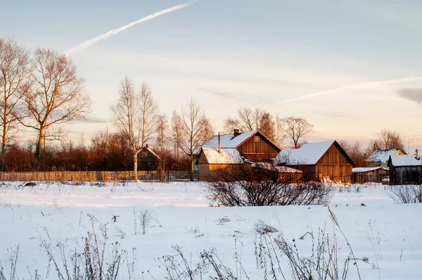 Village houses in winter in the evening in the sun.