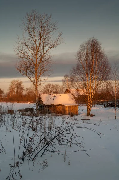 Village houses in winter in the evening in the sun.