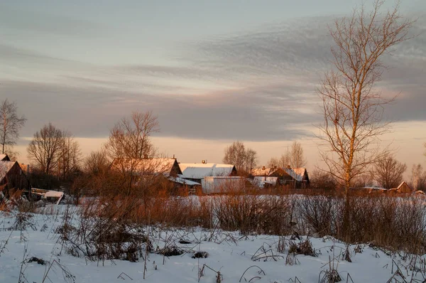 Village houses in winter in the evening in the sun.