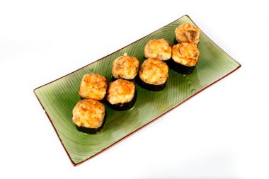 Hafif bir arka plan üzerinde, ulusal bir tabakta pişmiş suşi, Japon mutfağının bir kısmı.