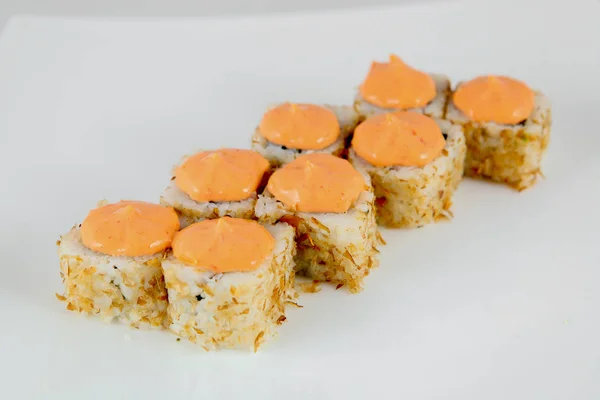 A portion of baked sushi, Japanese cuisine, on a national plate, on a light background.