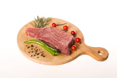 Pişmemiş et biftek biberiye, biber, domates ile ahşap masa