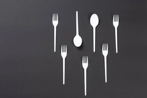 Gri arka planda plastik çatal ve kaşıklar
