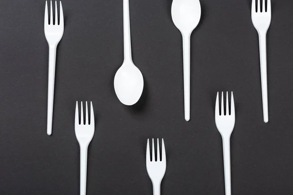 Gri arka planda plastik çatal ve kaşıklar