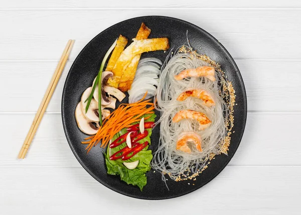 Black plate with food on white background