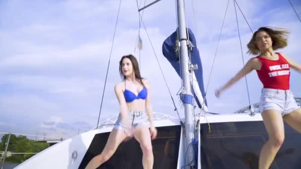 Две девушки танцуют на яхте — стоковое видео