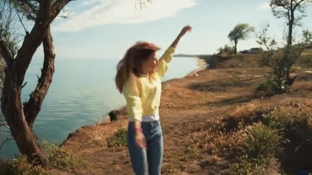 Happy girl saute sur une falaise au bord de la mer — Video