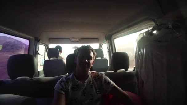 Guy rides in a minibus in the back seat — Stock Video