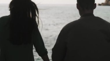 Denize ellerinden gelen bir çiftin gölgesi.