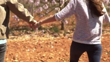 Genç çift çiçek bahçesinde yürüyor.