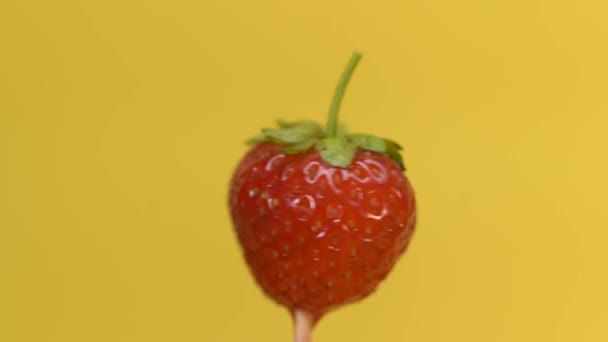 Aardbeien spinnen op een gele achtergrond — Stockvideo