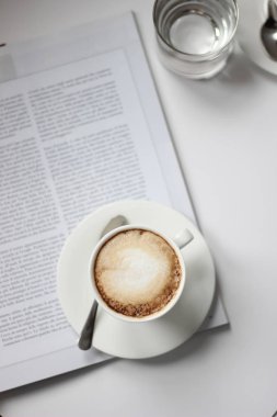 Kahve. Bir bardak taze demlenmiş kapuçino. Sabah kahve. Bir fincan kahve ile Delicious köpük moda dergisi ile beyaz arka plan üzerinde.